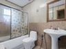 Full bath with bath / shower combo with glass door and tile walls