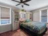 Bedroom with a ceiling fan and ornamental molding