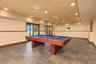 Recessed lighting illuminates the space, featuring tiled flooring, wood trim, and multiple glass-paned doors