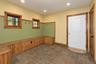 Built-in wood-finish bench seating, wood-finish window frames, recessed lighting, tile flooring, and wainscoting