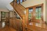 Hardwood flooring and staircase with wood balusters, newel posts, and handrails