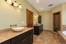 Dual vanity with vessel sinks, wall-mounted faucets, and stone countertops