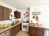 Kitchen featuring wood-finish cabinetry, a stainless steel double basin sink, and a white gas range