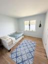 Window with water scenery, light wood-finish flooring, white trim, and light-toned walls