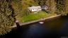 White siding residence with a gray roof and a green lawn