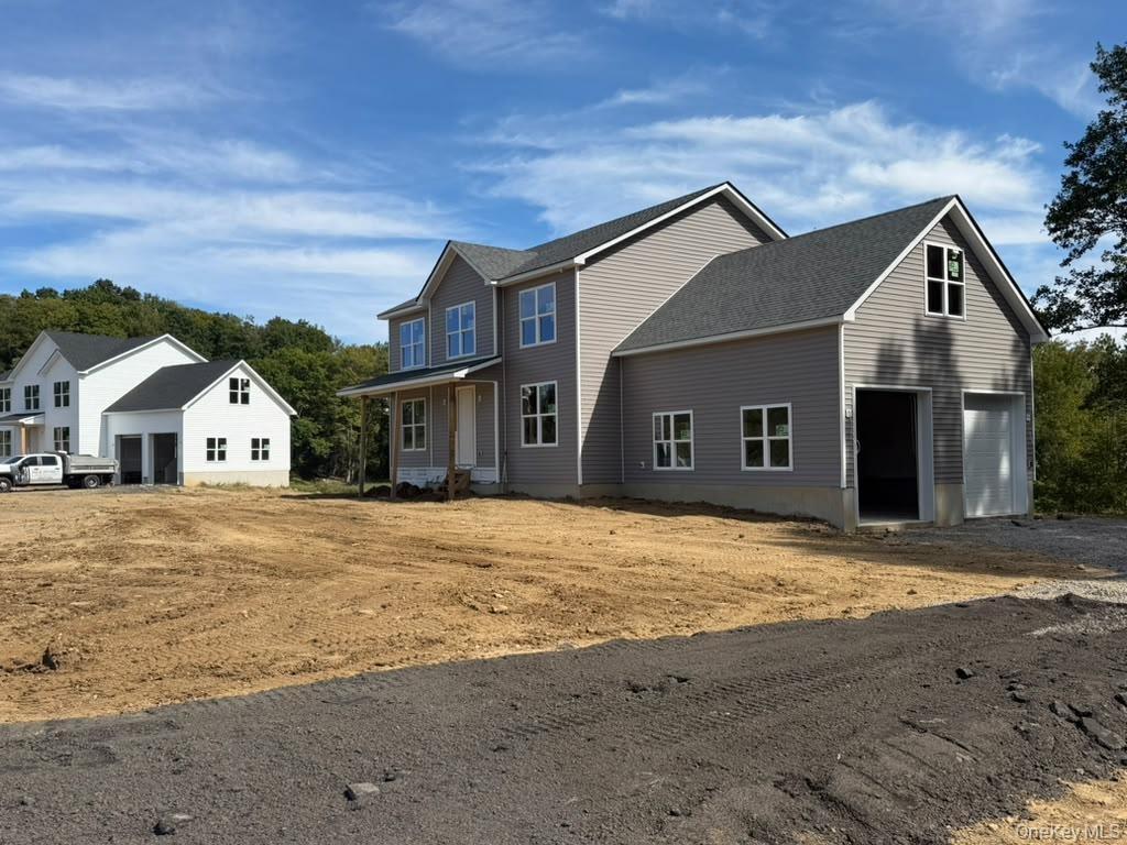Newly constructed residence featuring gray horizontal siding and a dark shingle roof