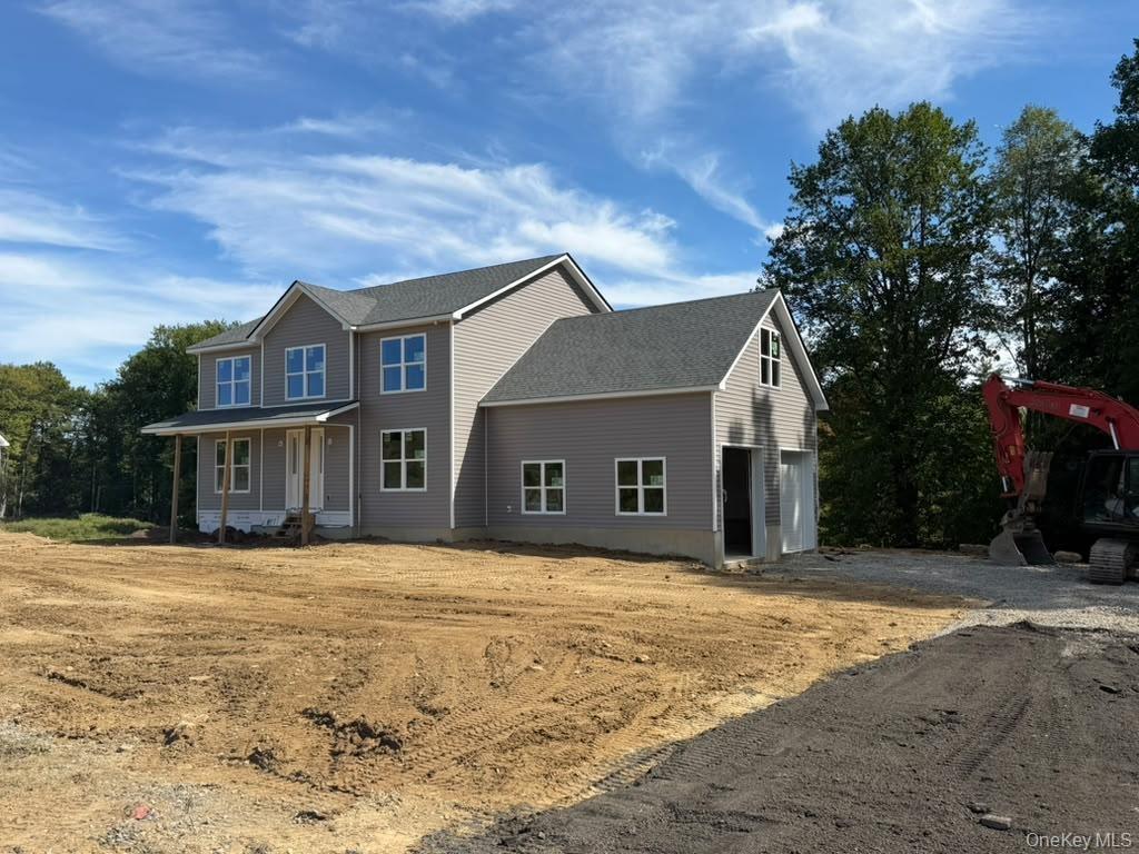 Two-story residence featuring light gray siding, white window frames, an attached two-car garage, a covered front porch, and a dark shingle roof