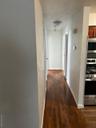 Corridor with dark wood-style floors and baseboards