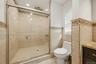Primary bathroom shower with marble tile.