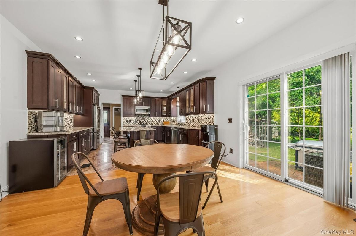 Dining room, with Anderson slider, that leads to a stamped concrete patio. Open to kitchen. Recessed lighting, wide plank white oak flooring and 9 foo