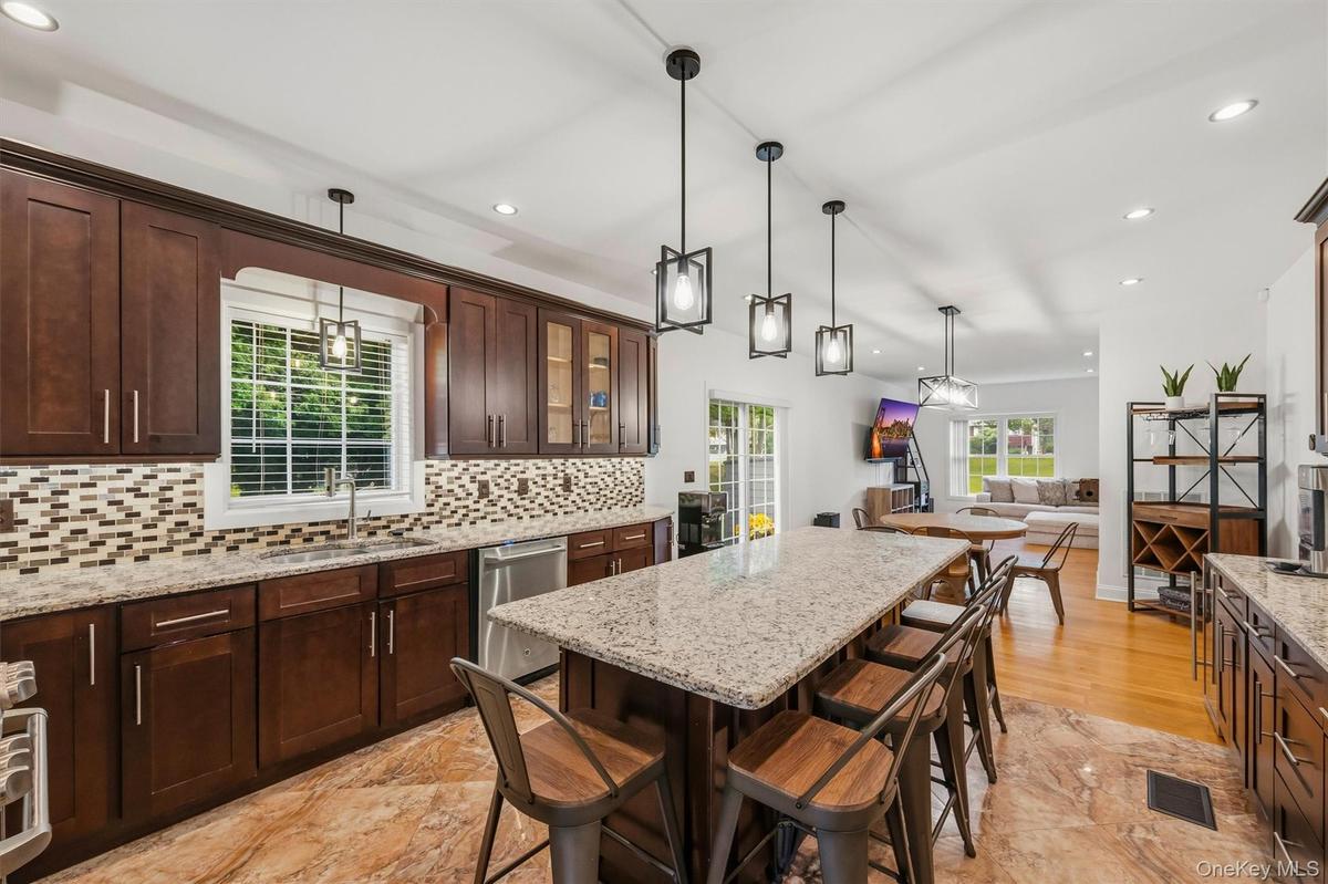 Kitchen with 7 foot 7 inch center island that seats 6, Anderson casement window above sink, Cafe appliances, granite countertops, tile backsplash, upl