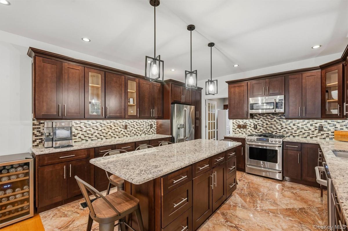 Kitchen with 7 foot 7 inch center island that seats 6, Anderson casement window above sink, Cafe appliances, granite countertops, tile backsplash, upl