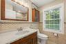 Hallway bathroom, marble tile, Anderson window, recessed lighting.