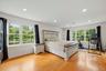 15x19 Primary Bedroom with recessed lighting, wide oak flooring and balcony access.