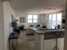 View of partial kitchen, dining and living room.