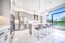 Kitchen featuring light gray cabinetry, stainless steel appliances, a center island with countertop seating, and a large picture window