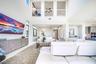 Soaring ceilings with upper-level balconies, expansive windows, recessed lighting, and a contemporary built-in media console