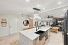 Waterfall countertop island featuring an integrated farmhouse sink and pendant lighting