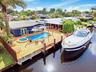 Waterfront property featuring a private dock, swimming pool, and integrated spa