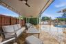 Covered patio with integrated ceiling fans, string lighting, paver patio, and a dedicated pool area