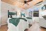 Vaulted wood-plank ceiling, wood-finish flooring, white shiplap-style wall, dual windows, and an installed air conditioning unit