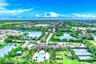 Community clubhouse with an outdoor swimming pool, multiple tennis courts, and surrounding water features