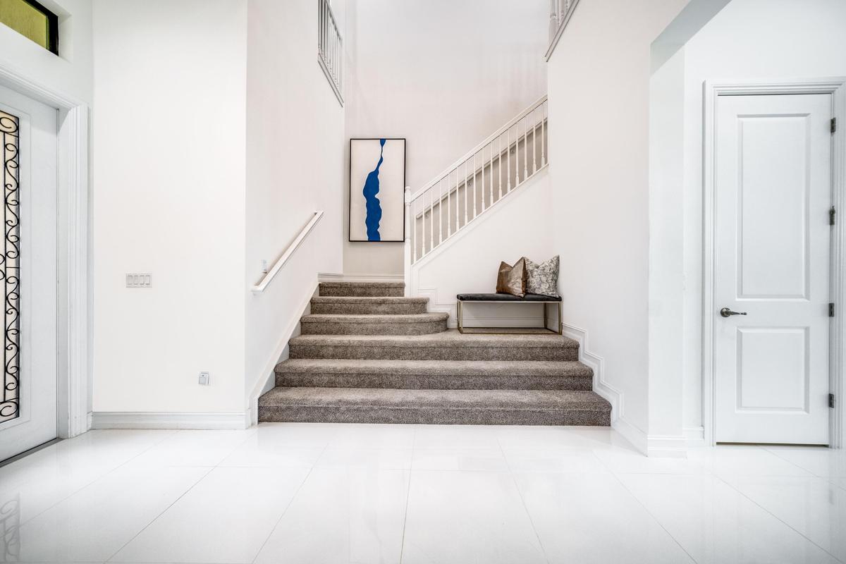 Spacious foyer with light-toned flooring and a white paneled door