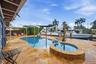 Freeform swimming pool with integrated spa and extensive paver patio