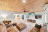 Wood-paneled ceiling, recessed lighting, ceiling fan, polished tile flooring, and multiple windows