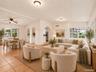 Virtually staged: great room with living and dining areas and arches to the kitchen