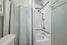 Tub and shower combination with subway tile surround, decorative tile accent, and a dual-function shower head