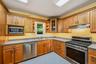 Wood-finish cabinetry with display cabinet, stainless steel appliances, and a built-in microwave