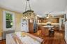 Open kitchen and dining area with center island, wood cabinetry, hardwood floors, and ample natural light