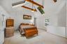 Another view highlighting the vaulted ceiling, skylights, exposed beams, and open layout