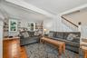 Spacious living room with wood floors, built-in bookshelves and staircase access