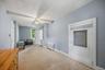 Ceiling fan light fixture, baseboard heating, window, white trim, and a built-in shelf