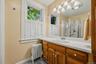 Full bath with wood vanity, large mirror, and walk-in shower