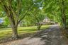 Tree-lined setting with a spacious lawn and long driveway