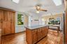 Spacious kitchen with center island, wood cabinetry, hardwood floors, and plenty of natural light