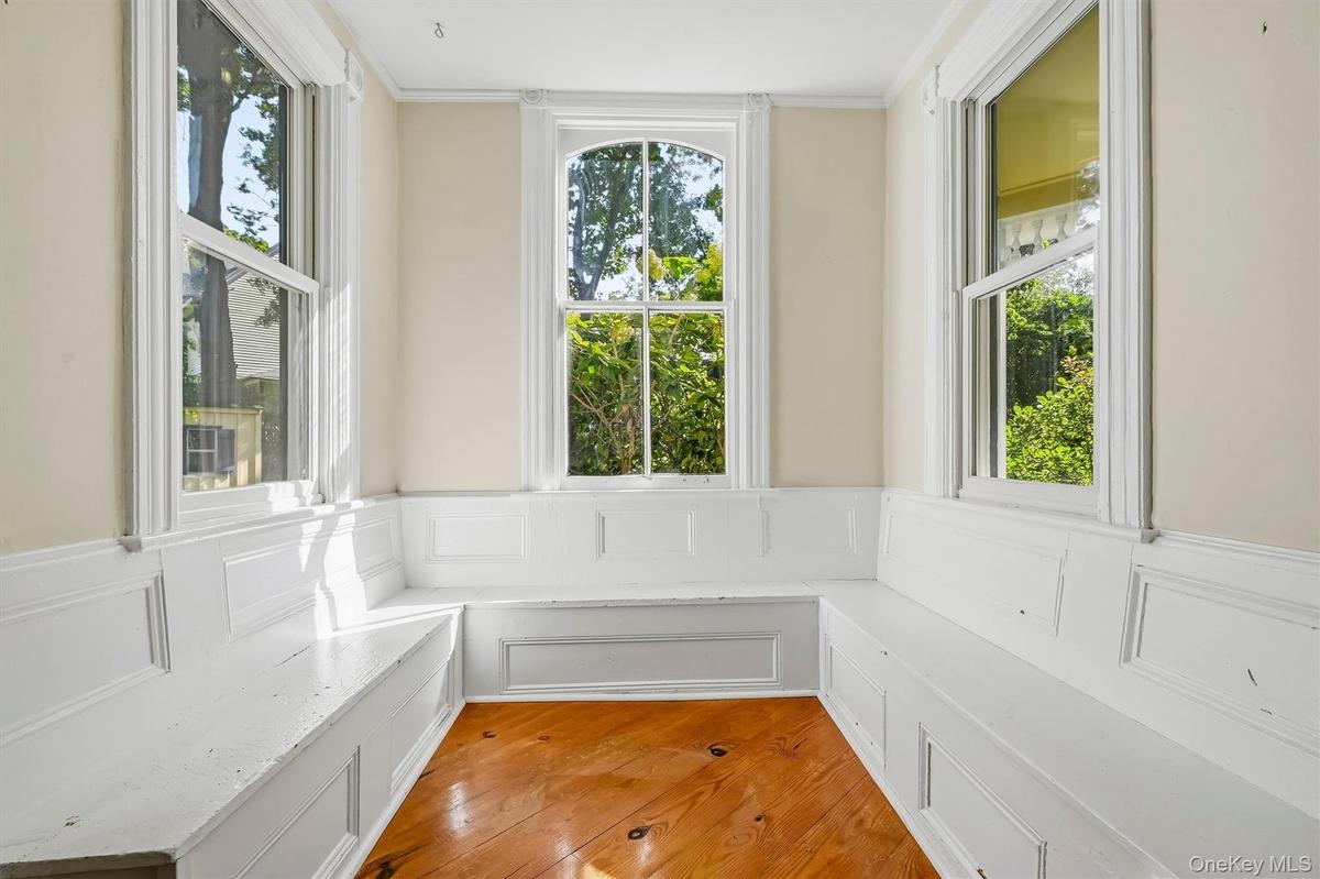 Bright reading nook surrounded by windows and built-in bench seating