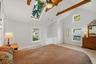 Bright primary bedroom with multiple windows and distinctive vaulted ceiling