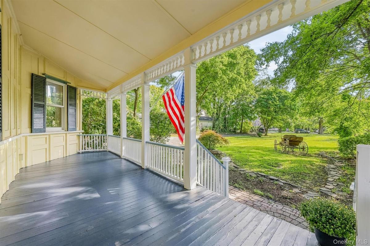 Covered porch with painted wood flooring and decorative balusters