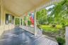Covered porch with painted wood flooring and decorative balusters