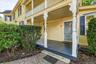 Welcoming covered porch with decorative columns and brick walkway