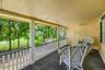 Spacious porch offering a peaceful view of the surrounding yard and mature trees