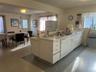 Kitchen featuring a textured ceiling, sink, white cabinets, and white appliances