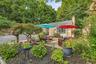 Incredible landscaping and gardens surround this charm filled home.