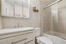 Unit 2 - Bathroom with bathtub and glass enclosure. Digitally decluttered.