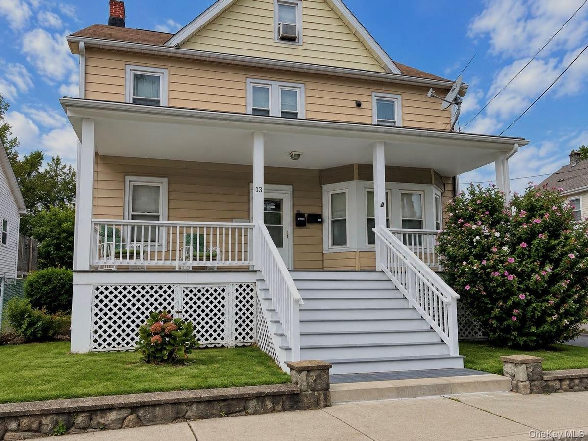 Two-story residence with a covered front porch featuring white railings