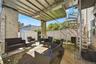 Covered rear patio beneath the balcony. Digitally decluttered.